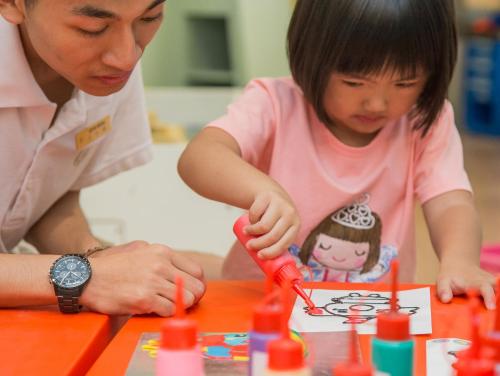 a woman and a girl playing with a toy at Freshfields Hotel in Wuri