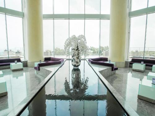a lobby with a table with a vase in the water at Freshfields Hotel in Wuri