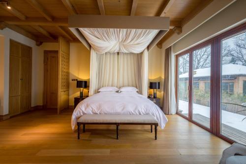 a bedroom with a bed and a large window at Evergreen Retreat-walk to National Forest Park, free pick up service in Zhangjiajie