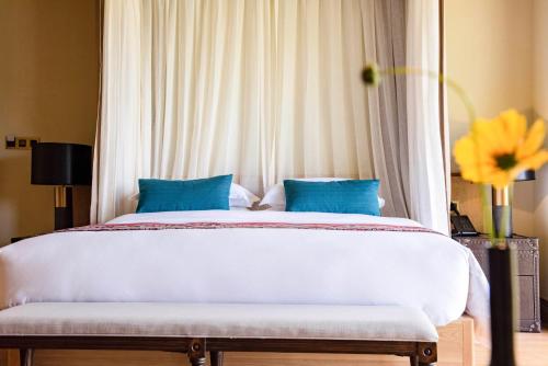 a bedroom with a large bed with blue pillows at Evergreen Retreat-walk to National Forest Park, free pick up service in Zhangjiajie