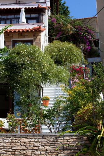 a house with bushes and flowers in front of it at Notis Hotel in Samos