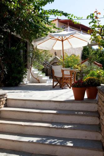 a patio with a table and an umbrella at Notis Hotel in Samos