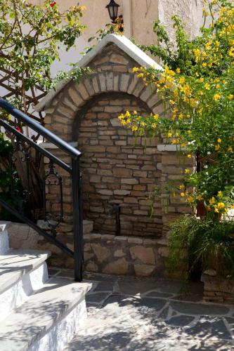 an outdoor brick oven in a building with yellow flowers at Notis Hotel in Samos