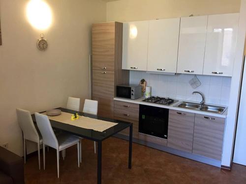 a kitchen with a table and chairs and a kitchen with white cabinets at Appartamento Guercino in Cento
