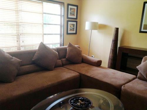 a living room with a couch and a table at Citystate Asturias Hotel Palawan in Puerto Princesa City