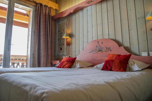 a bedroom with a large bed with a pink headboard at Le Paquis in Tignes