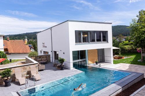 a house with a swimming pool in the backyard at Hotel St. Florian in Frauenau