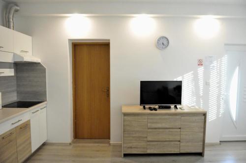 a kitchen with a tv on top of a wooden cabinet at Rooms LU&LA in Velika Gorica