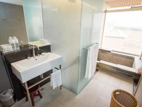 a bathroom with a sink and a shower at Freshfields Hotel in Wuri