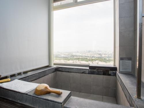 a bath tub in a building with a large window at Freshfields Hotel in Wuri