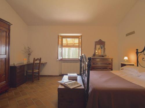 ein Schlafzimmer mit Bett, Schreibtisch und Fenster in der Unterkunft Beautiful Farmhouse with Pool in Arezzo