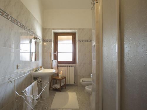 ein Badezimmer mit Waschbecken und Toilette und Waschbecken in der Unterkunft Beautiful Farmhouse with Pool in Arezzo