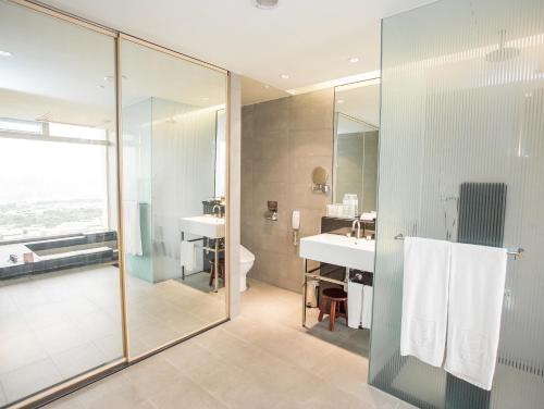 a bathroom with a shower and a sink and a toilet at Freshfields Hotel in Wuri