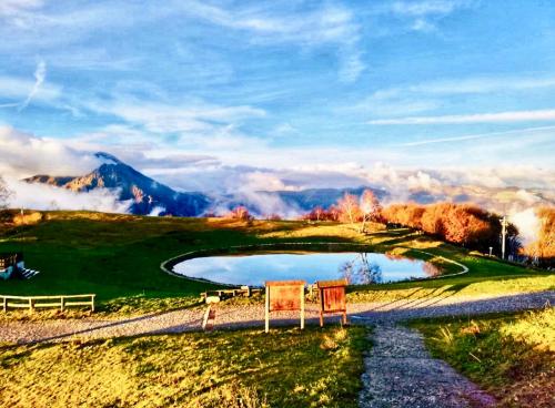 a golf course with a pond on a hill at Il Roccolino in Valsecca
