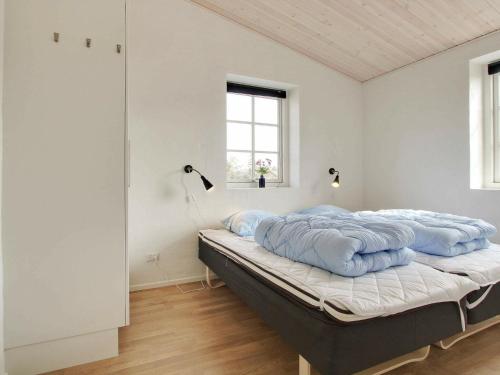 um quarto com uma cama com almofadas azuis em Five-Bedroom Holiday home in Blåvand 22 em Blåvand