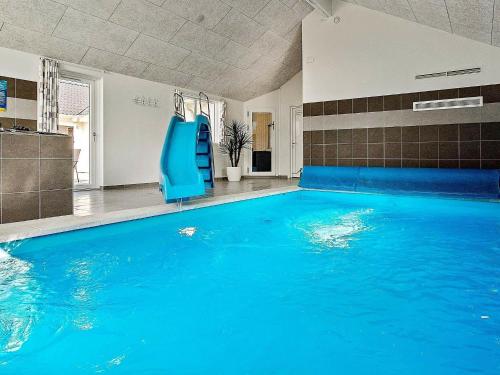 a swimming pool with a blue chair in a room at 20 person holiday home in Hasselberg in Kappeln