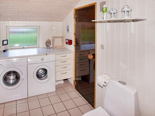 FjerbækにあるHoliday Home Bambivejのバスルーム(洗濯機、シンク付)
