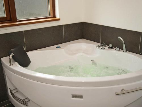 El baño incluye bañera blanca con lavamanos. en 8 person holiday home in Ulfborg en Thorsminde