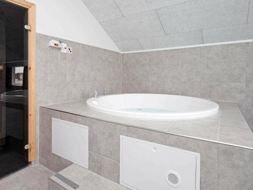 La salle de bains est pourvue d'une baignoire blanche. dans l'établissement Five-Bedroom Holiday home in Bogense, à Bogense