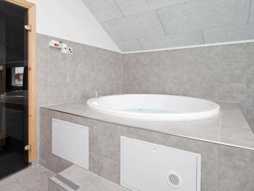 a bathroom with a white tub in a room at Luxury Retreat by Skastrup - By Traum Ferienwohnungen in Bogense