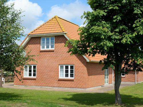 una casa de ladrillo rojo con un árbol delante en 14 person holiday home in Bl vand, en Ho