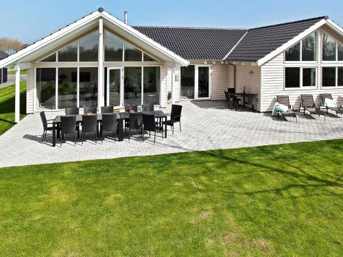 a patio with chairs and tables in front of a house at 18 person holiday home in Hasselberg in Kappeln