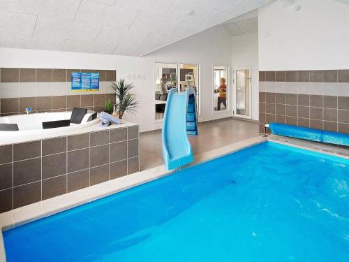 a large swimming pool with a slide in a room at 18 person holiday home in Hasselberg in Kappeln