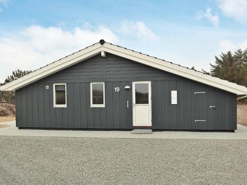 a black garage with a white door at 8 person holiday home in Henne in Henne Strand