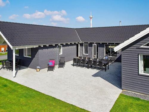 une maison avec une terrasse dotée de chaises et un bâtiment dans l'établissement 20 person holiday home in Hasselberg, à Kappeln