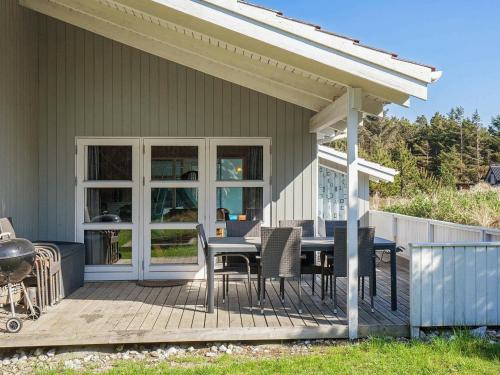 a porch with a table and chairs on a deck at 10 person holiday home in Thisted in Klitmøller