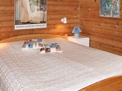 ÅlbækにあるThree-Bedroom Holiday home in Ålbæk 48の木製の壁のベッドルーム1室(ベッド1台付)
