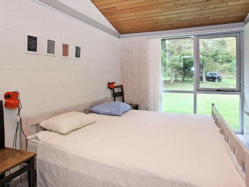 - une chambre avec un lit et une grande fenêtre dans l'établissement Holiday Home Tippen, à Saltum