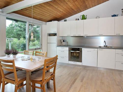 a kitchen with white cabinets and a wooden table at 6 person holiday home in Saltum-By Traum in Saltum