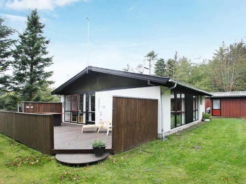 a small house with a wooden deck in a yard at 6 person holiday home in Saltum-By Traum in Saltum