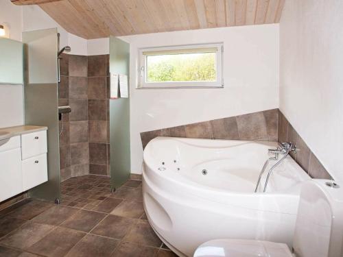 a white bath tub in a bathroom with a window at 6 person holiday home in Tarm in Tarm