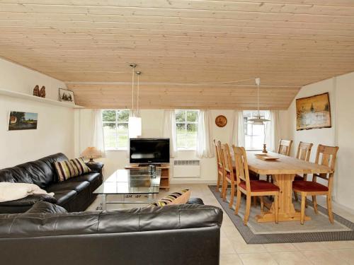 ホにあるTwo-Bedroom Holiday home in Blåvand 28のリビングルーム(革張りのソファ、テーブル付)