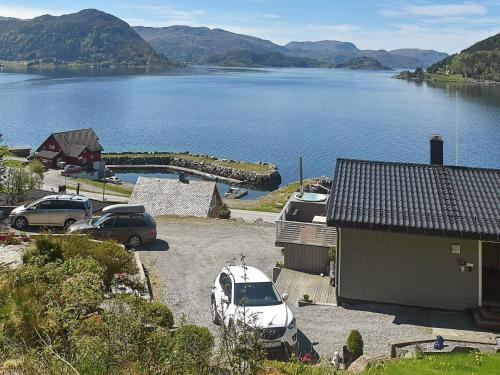 um grupo de carros estacionados num parque de estacionamento ao lado de um lago em 4 person holiday home in Selje em Selje