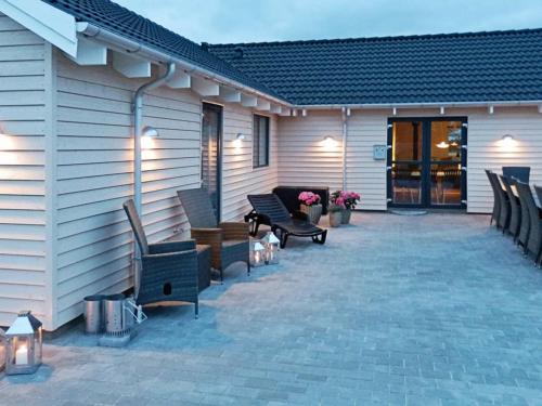 un patio avec des chaises et des tables à côté d'un bâtiment dans l'établissement 22 person holiday home in Bogense, à Bogense