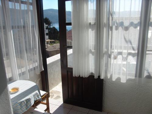 a door to a room with a view of a balcony at Notis Hotel in Samos