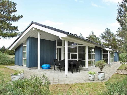 Torup Strandにある10 person holiday home in Fjerritslevのパティオ(テーブル、椅子付)が備わる家です。