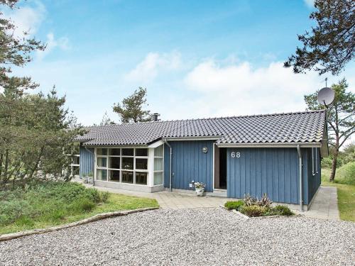uma casa com uma garagem azul e branca em 10 person holiday home in Fjerritslev em Torup Strand