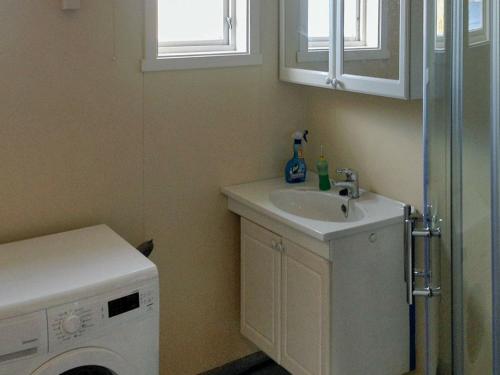 a bathroom with a sink and a washing machine at Holiday Home Breivikbotn in Vatna