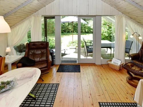 een woonkamer met lederen meubels en een patio bij 4 person holiday home in Oksb l in Oksbøl