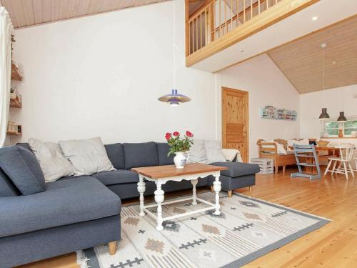 a living room with a blue couch and a table at 8 person holiday home in J gerspris in Jægerspris