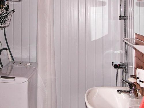 Baño blanco con lavabo y aseo en Three-Bedroom Holiday home in Ålbæk 48 en Ålbæk