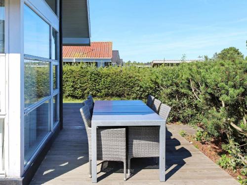 einen blauen Tisch und Stühle auf einer Veranda mit Aussicht in der Unterkunft 6 person holiday home in Hadsund in Øster Hurup