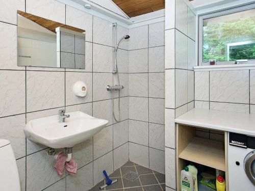 La salle de bains est pourvue d'un lavabo et d'une douche. dans l'établissement Holiday Home Tippen, à Saltum