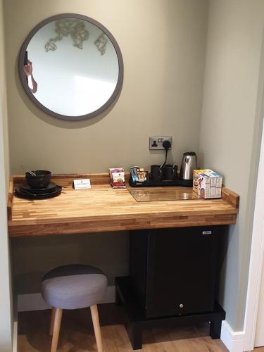 a wooden desk with a mirror and a stool at Open acres accommodation and airport parking in Bristol