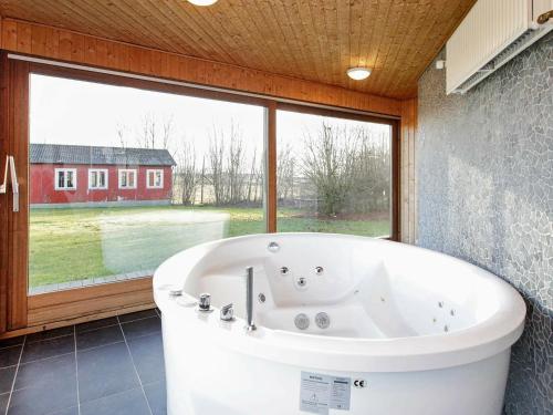 a bath tub in a bathroom with a large window at Holiday Home Åstedvej in Åsted