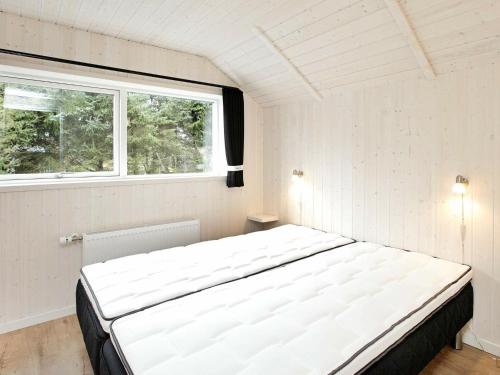 een groot wit bed in een kamer met een raam bij Holiday home Blåvand IX in Blåvand